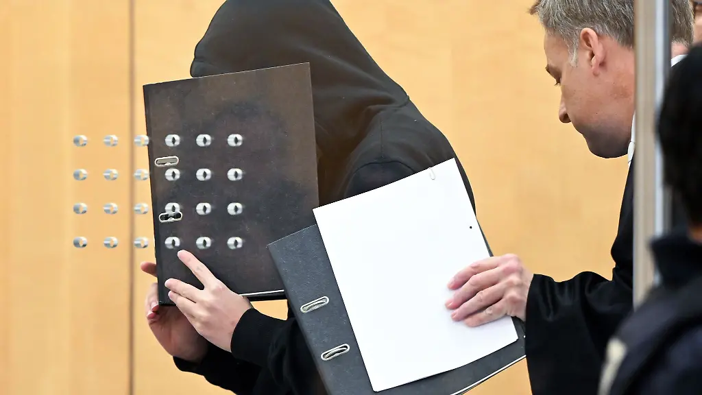 Der-Angeklagte-l-verdeckt-sein-Gesicht-neben-ihm-sein-Verteidiger-Andreas-Wieser