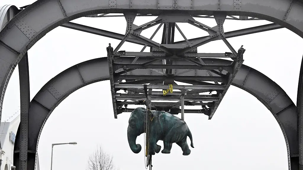 Die-Bronzeskulptur-des-Bildhauers-Joerg-Mazur-haengt-an-einem-Tragegeruest-der-Wuppertaler-Schwebebahn