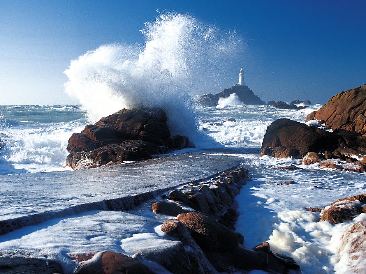 Milde Winter, aber manchmal eine raue See: An Jerseys Küste brechen sich die Wellen oft mit voller Wucht. Die Gischt scheint dann höher zu sein als der Leuchtturm La Corbière im Inselwesten.