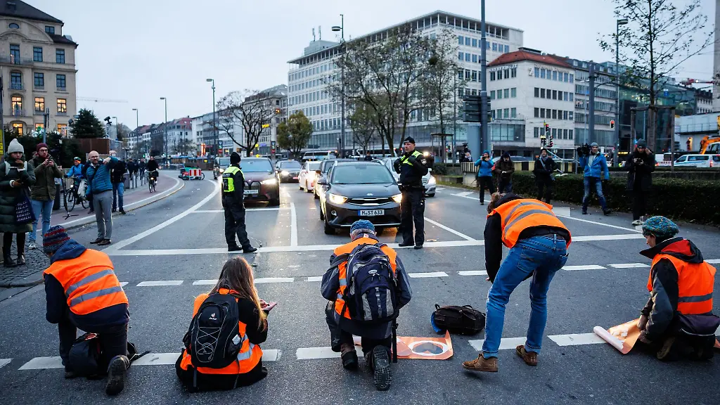 Aktivisten-der-Klimaschutz-Initiative-Letzte-Generation-kleben-sich-am-Stachus-mit-ihren-Haenden-auf-die-Strasse