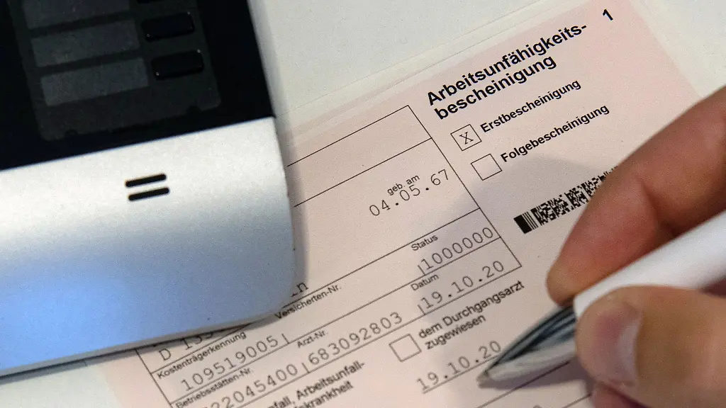 Ein-Mitarbeiter-einer-Arztpraxis-notiert-etwas-auf-einer-Arbeitsunfaehigkeitsbescheinigung
