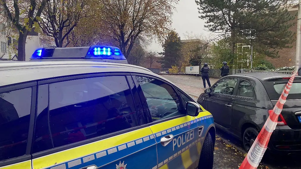 Ein-Polizeiauto-und-zwei-Polizisten-stehen-vor-einer-Berufsschule-in-Dueren