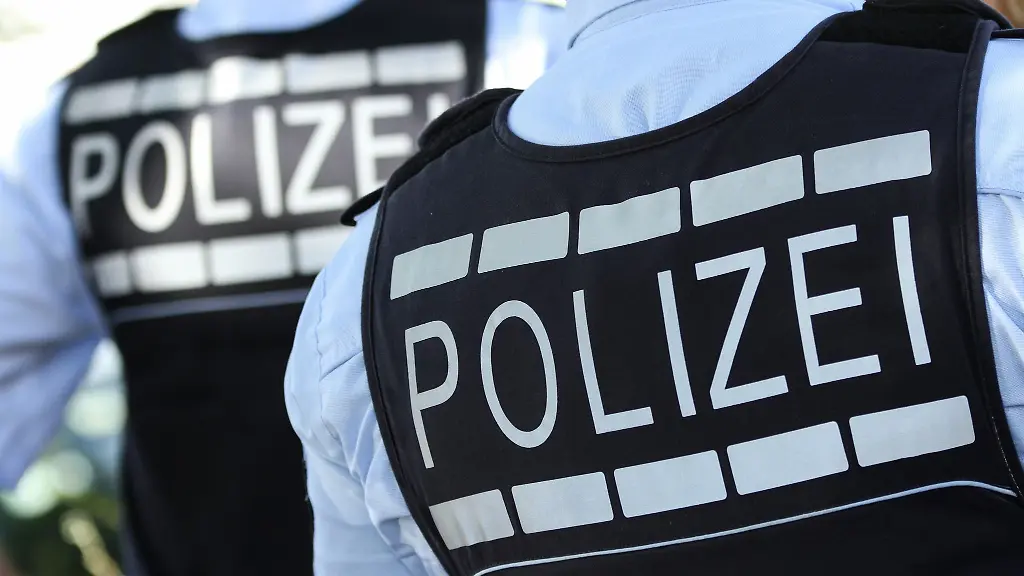 In-Polizei-Westen-gekleidete-Polizisten-stehen-in-der-Stadt