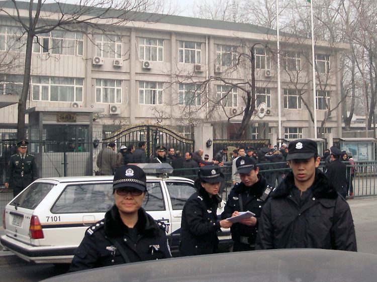 Chinesische Sicherheitskräfte verfolgen das Agieren von Demonstranten vor der libyschen Botschaft in Peking.