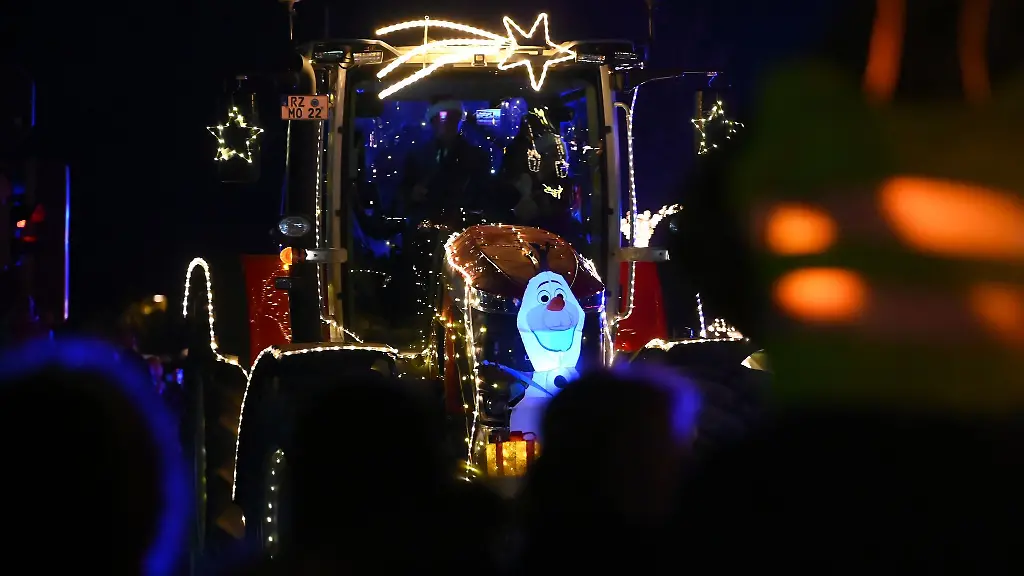 Aufwendig-dekorierte-Traktoren-fahren-an-zahlreichen-Schaulustigen-vorbei