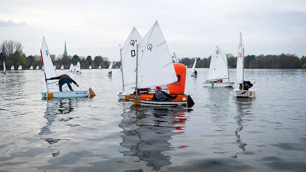 Teilnehmende-umrunden-mit-ihren-Optimisten-Jollen-waehrend-der-Eisarsch-Regatta-einen-Wendepunkt