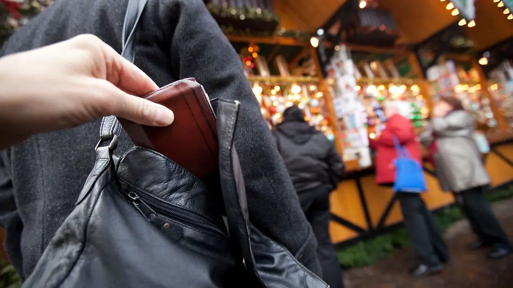 Ein-Mann-zieht-auf-dem-Weihnachtsmarkt-einer-Besucherin-die-Geldboerse-aus-der-Handtasche