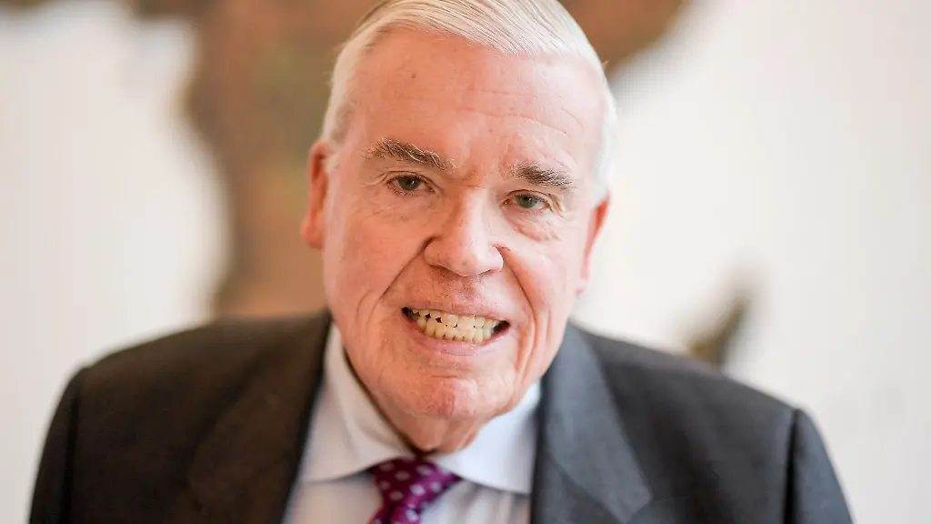 Klaus-Michael-Kuehne-Unternehmer-steht-im-Hauptsitz-der-Kuehne-und-Nagel-AG-vor-einer-Weltkarte