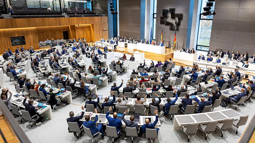 Abgeordnete-heben-bei-einer-Abstimmung-waehrend-einer-Sitzung-vom-niedersaechsischen-Landtag-ihre-Hand