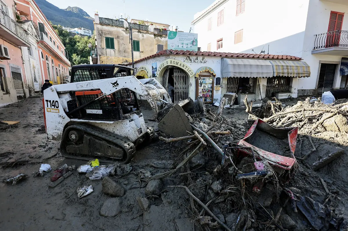 Ein-Arbeiter-raeumt-mit-einem-Bagger-eine-Strasse-frei