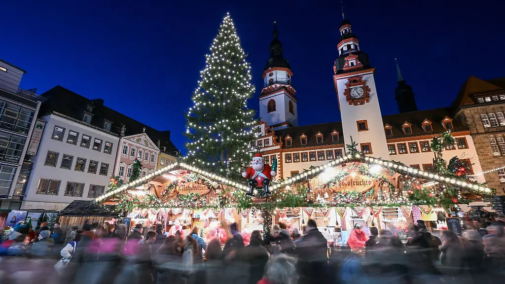 Besucher-gehen-vor-der-Kulisse-des-Alten-Rathauses-ueber-den-Weihnachtsmarkt-in-Chemnitz