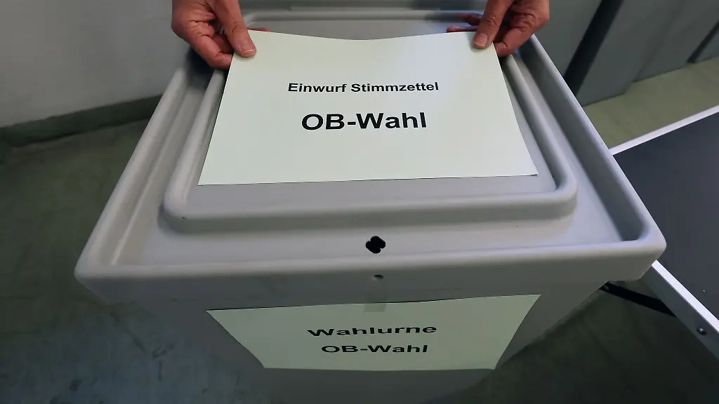 Im-Materiallager-fuer-Wahlen-zeigt-ein-Mitarbeiter-eine-Wahlurne
