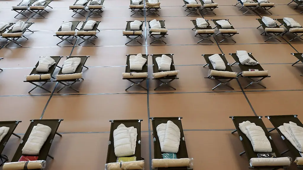 Feldbetten-stehen-im-Sommer-in-einer-Notunterkunft-fuer-Fluechtlinge