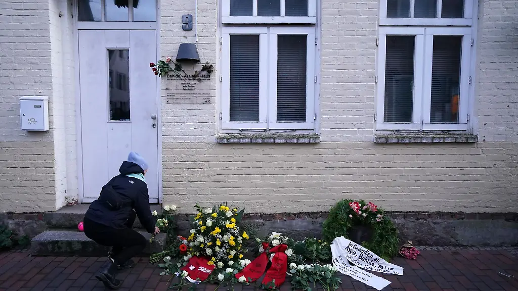 Eine-Frau-legt-Blumen-waehrend-einer-Gedenkveranstaltung-vor-dem-Bahide-Arslan-Haus-ab
