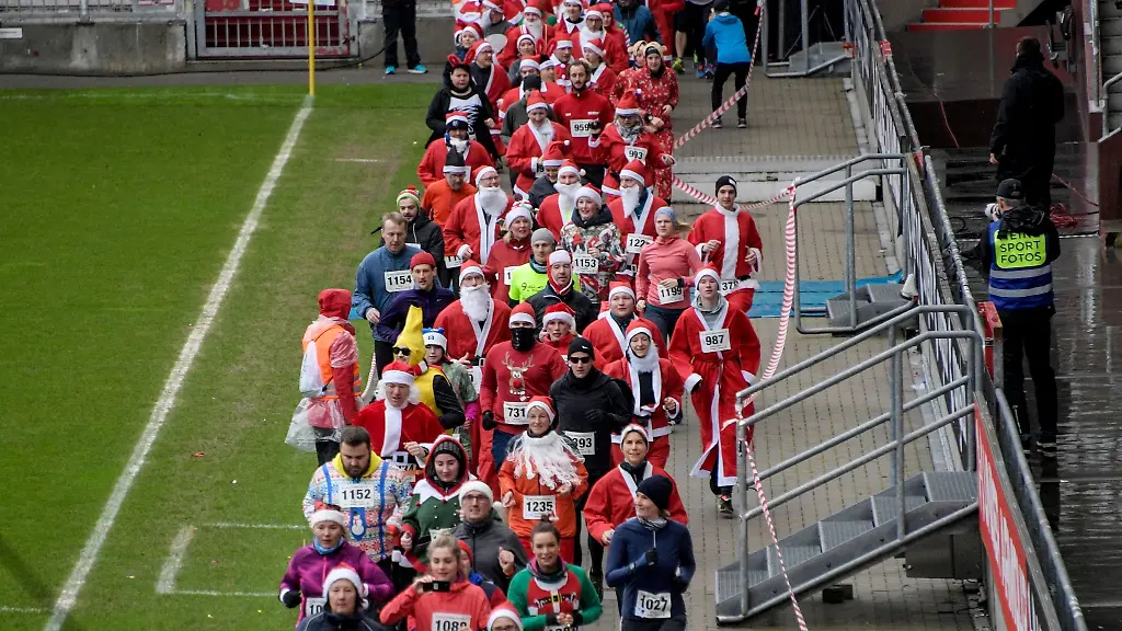 Teilnehmerinnen-und-Teilnehmer-laufen-in-weihnachtlichen-Verkleidungen-durch-das-Millerntorstadion