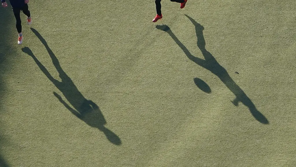 Kinder-spielen-auf-einem-Kunstrasenplatz-Fussball