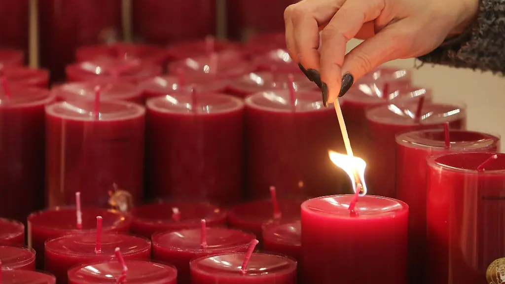 Eine-Frau-zuendet-eine-Kerze-an