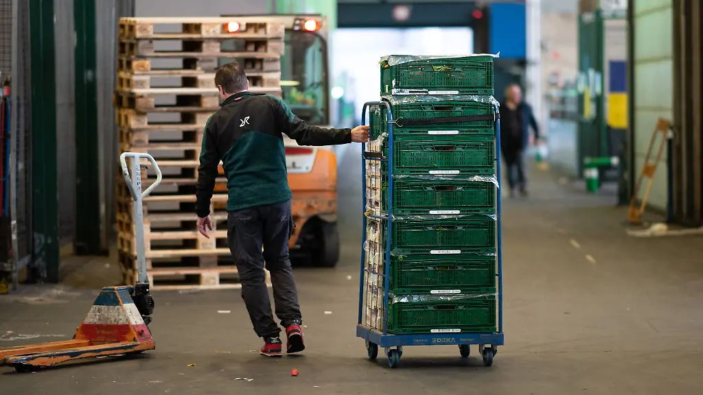 Ein-Haendler-zieht-einen-Wagen-mit-Obst-und-Gemuesekisten