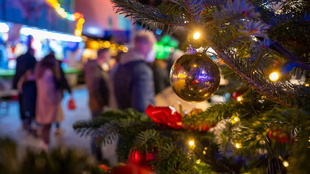Ein-festlich-geschmueckter-Baum-steht-auf-einem-Weihnachtsmarkt