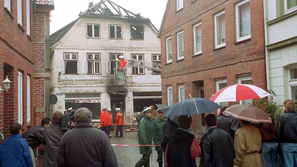 Feuerwehrleute-sichern-das-nach-einem-rechtsextremistischen-Brandanschlag-ausgebrannte-Haus