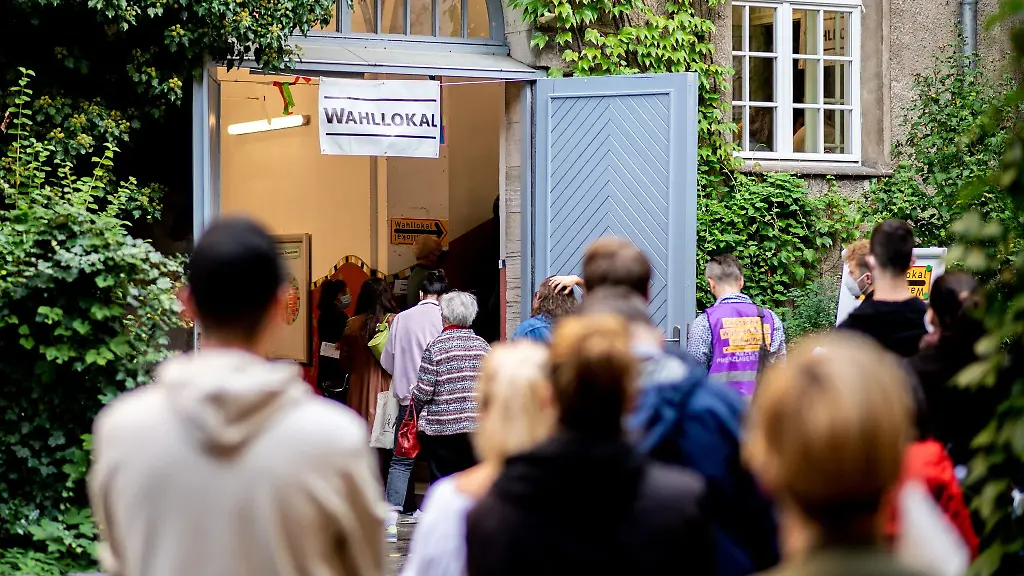 Waehlerinnen-und-Waehler-warten-im-Stadtteil-Prenzlauer-Berg-in-einer-langen-Schlange-vor-einem-Wahllokal-das-in-einer-Grundschule-untergebracht-ist
