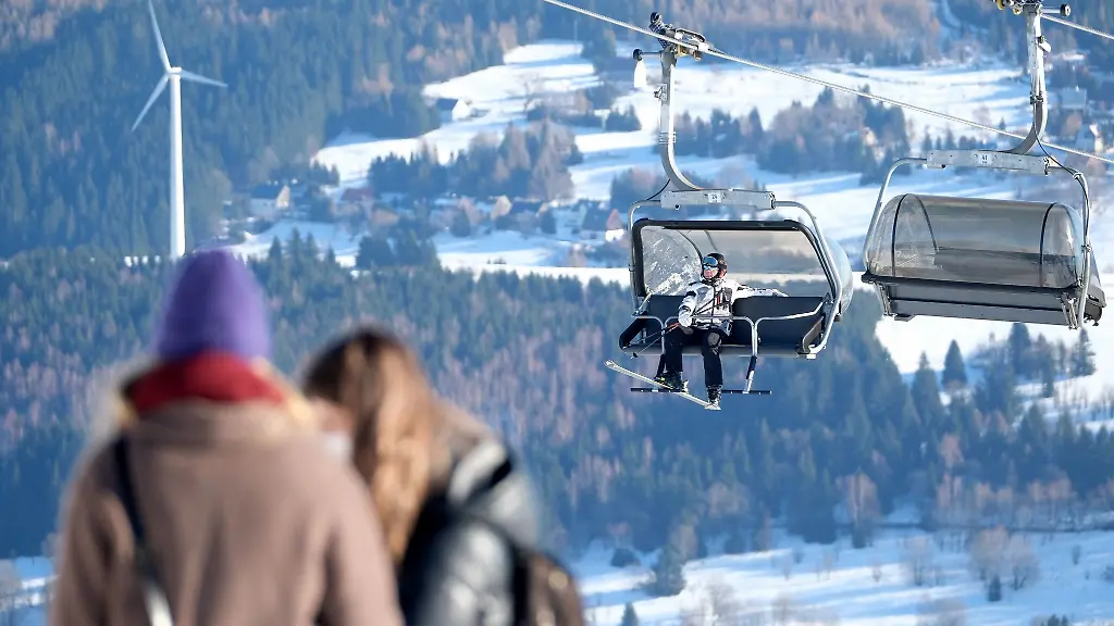 Ein-Wintersportler-sitzt-in-der-Gondel-eines-Liftes-auf-dem-Fichtelberg