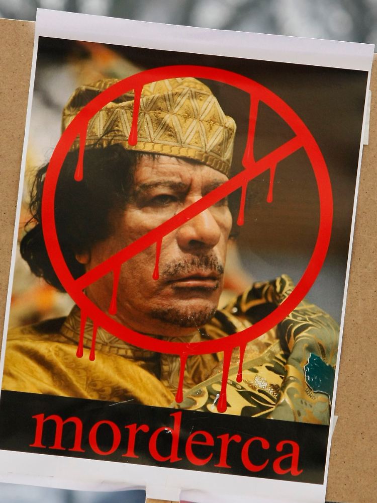 "Mörder" steht unter einem Gaddafi-Plakat.