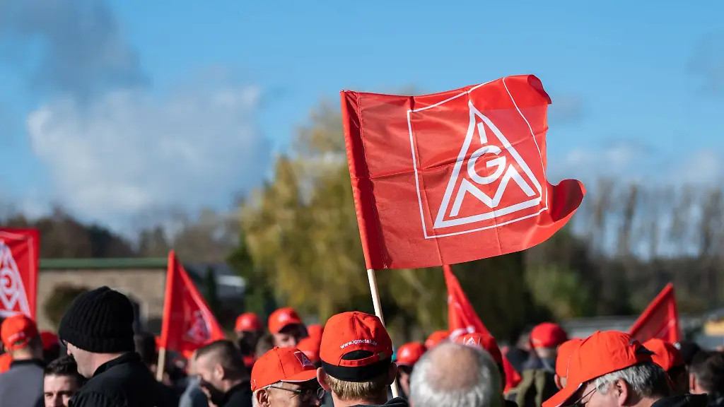 Teilnehmer-einer-Kundgebung-der-Gewerkschaft-IG-Metall-waehrend-eines-Warnstreiks
