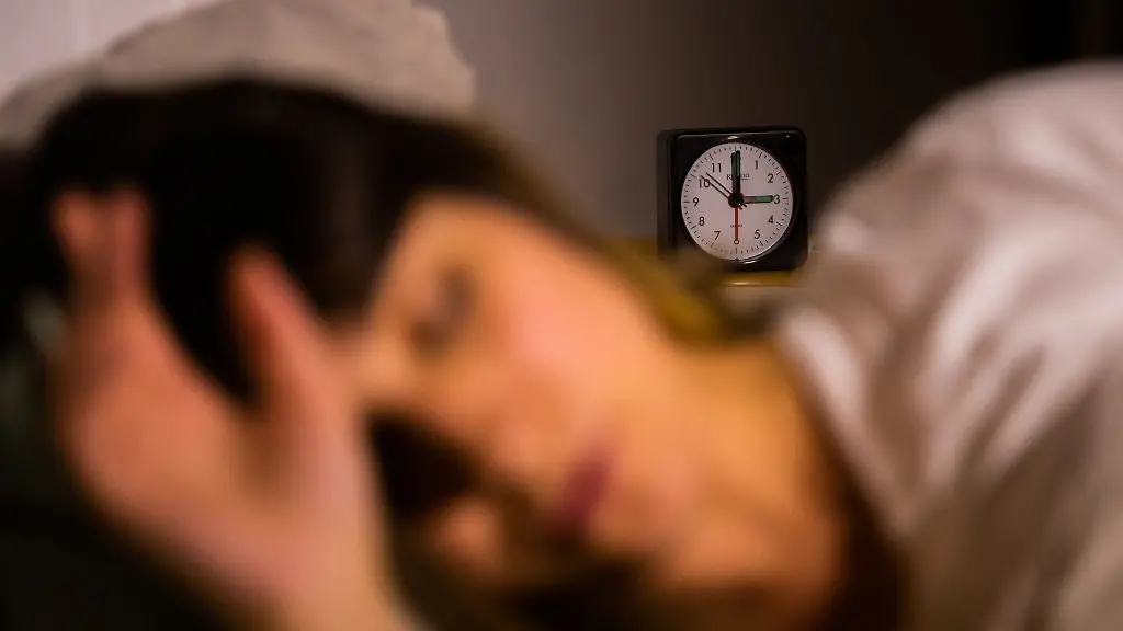 Eine-Frau-schlaeft-neben-einem-Wecker-welcher-auf-3-Uhr-zeigt