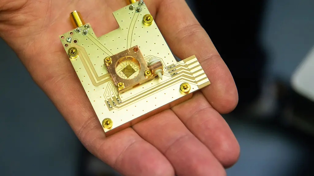 Ein-Physiker-haelt-einen-Quantenprozessor-in-der-Hand