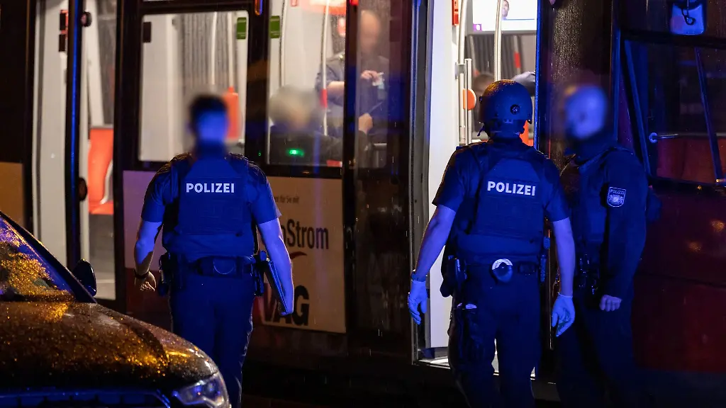Polizisten-stehen-neben-einer-Strassenbahn-in-der-naehe-des-Tatorts