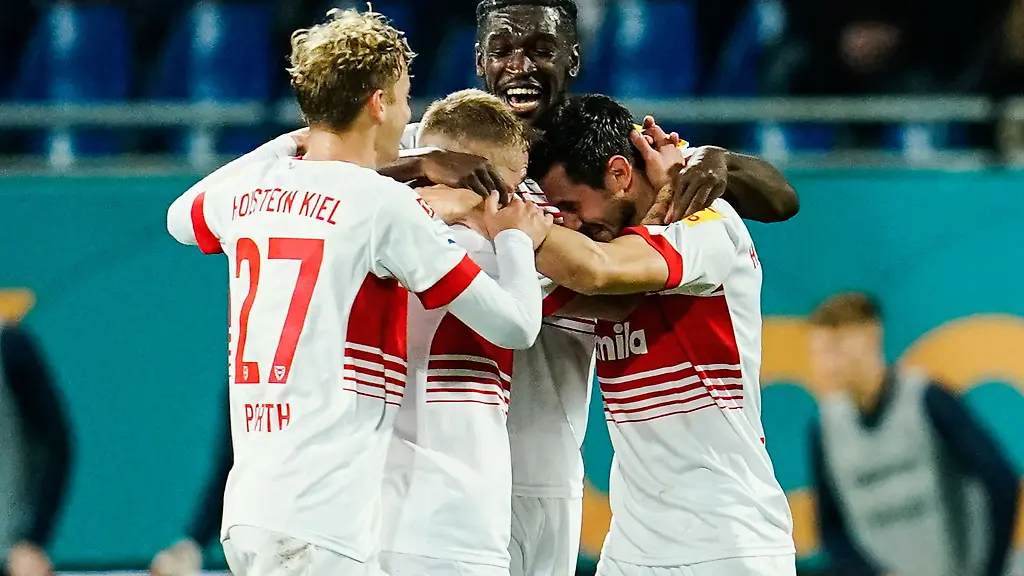 Kiels-Torschuetze-Steven-Skrzybski-r-jubelt-mit-Mannschaftskollegen-ueber-das-Tor-zum-0-1