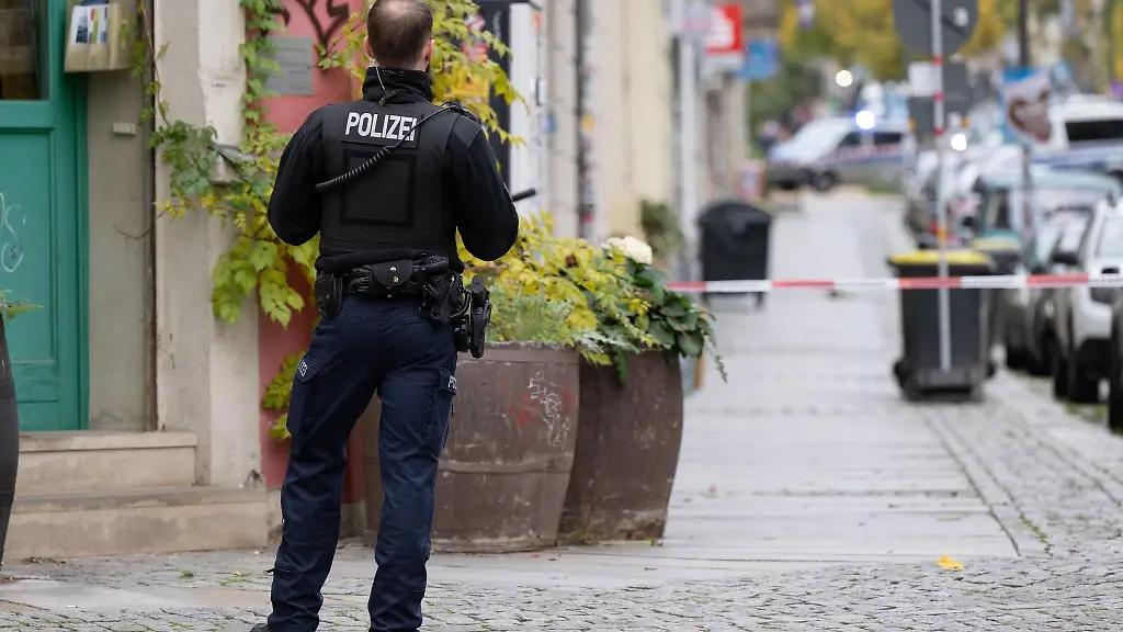 Ein-Polizist-steht-im-Stadtteil-Leipziger-Vorstadt-auf-der-Rudolf-Leonhard-Strasse-vor-einem-Absperrband