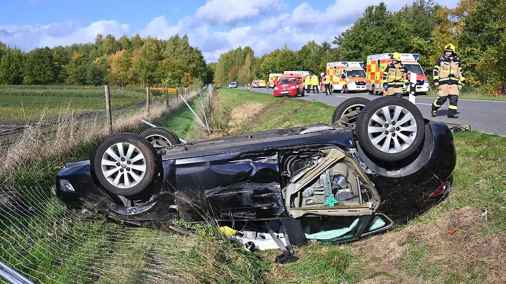 Das-zerstoerte-Auto-liegt-auf-dem-Dach-im-Strassengraben