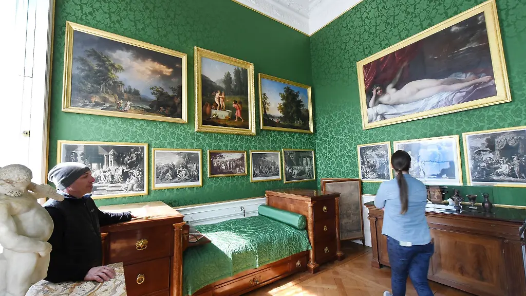 Besucher-stehen-waehrend-einer-Fuehrung-im-Schloss-Woerlitz-im-Schlafzimmer-des-Fuersten-Leopold-III