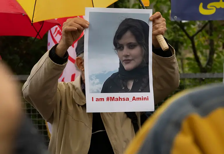 Bei-einem-Protest-in-Berlin-haelt-ein-Mann-ein-Bild-der-verstorbenen-Mahsa-Amini-in-Haenden