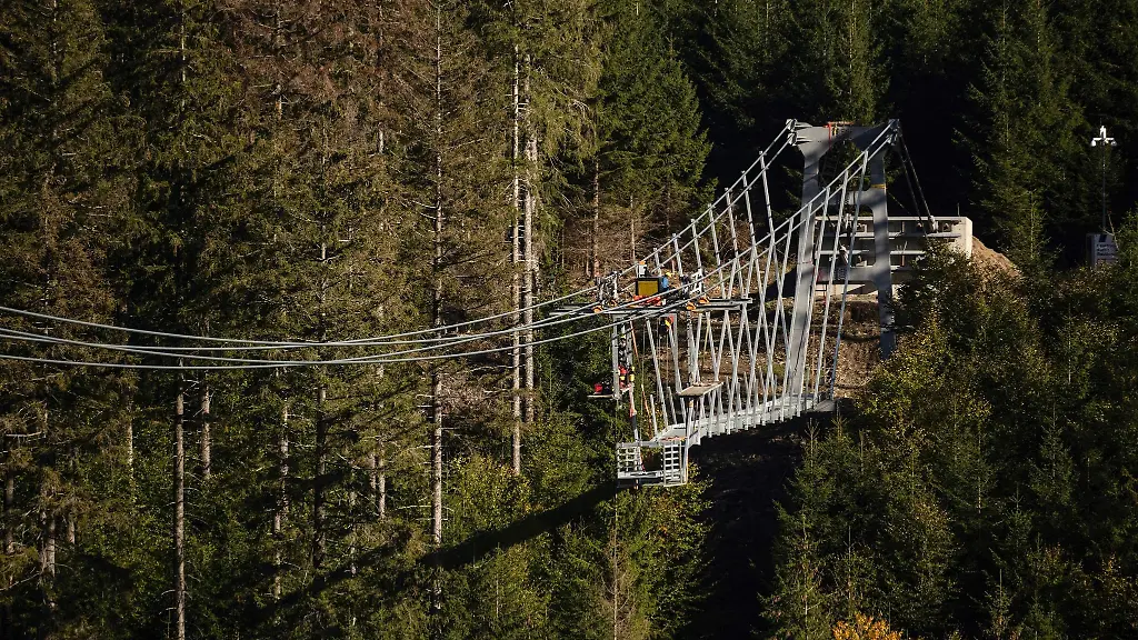 Arbeiter-fahren-mit-Bauteilen-an-Drahtseilen-der-Haengebruecke-Skywalk-Willingen-zur-Baustelle