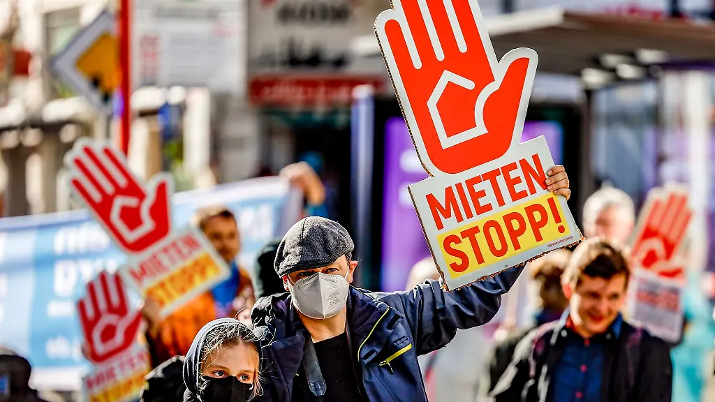 Teilnehmer-halten-ein-Plakat-mit-der-Aufschrift-Mieten-Stopp-in-den-Haenden