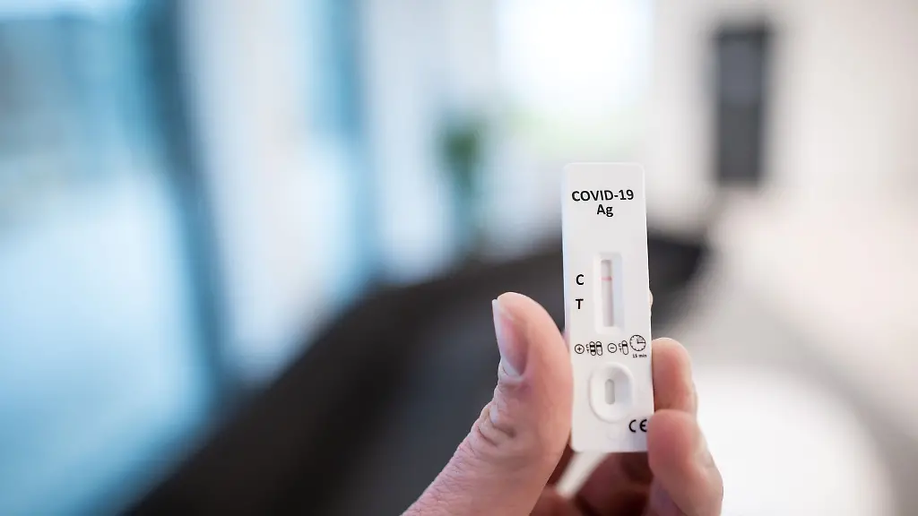 Ein-Mann-haelt-einen-Corona-Schnelltest-in-der-Hand