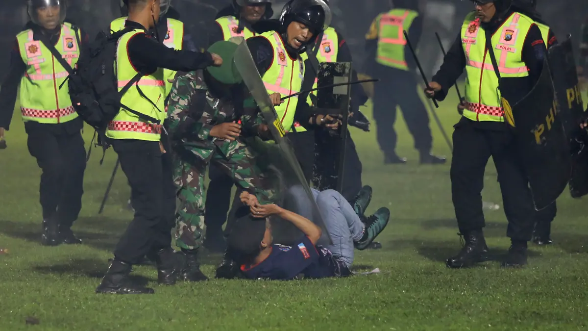 Sicherheitsbeamte-halten-einen-Fan-waehrend-Zusammenstoessen-nach-dem-Erstliga-Spiel-zwischen-Arema-FC-und-Persebaya-FC-fest