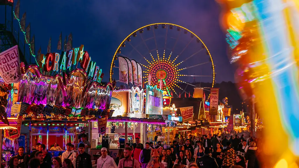 Besucher-gehen-am-Eroeffnungstag-des-Cannstatter-Volksfest-auf-dem-Wasen-in-Stuttgart