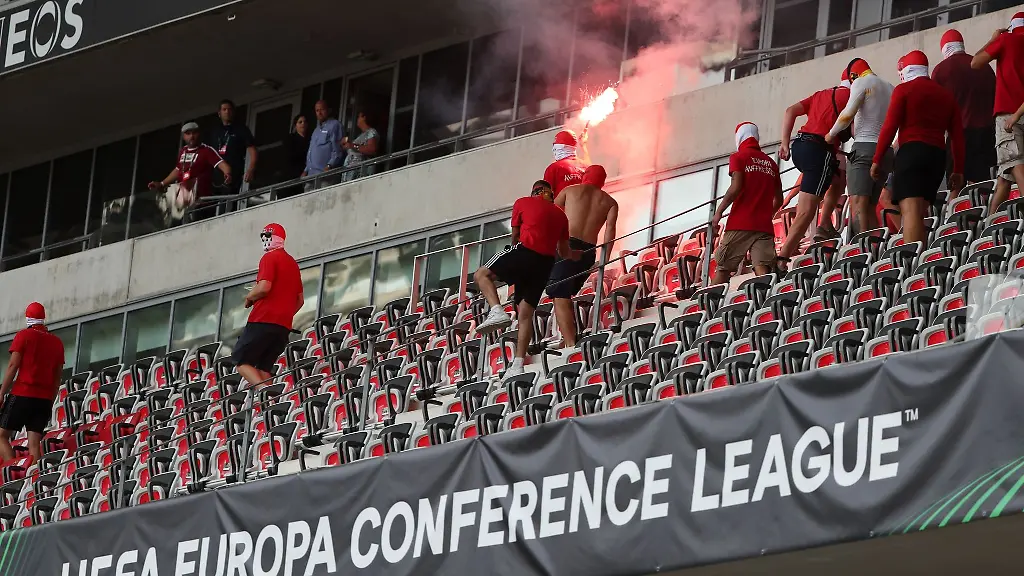 Fans-laufen-mit-Pyrotechnik-ueber-eine-Tribuene