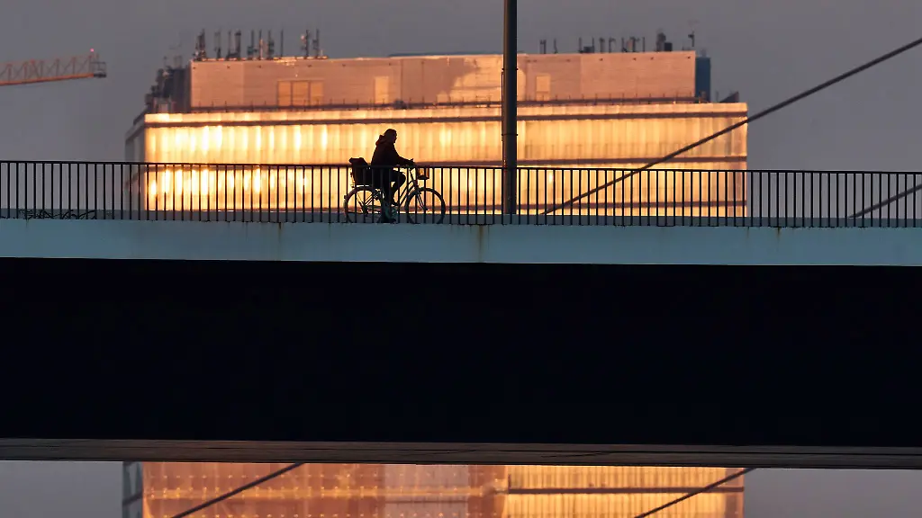Ein-Radfahrer-ist-am-Morgen-auf-der-Rheinbruecke-in-Duesseldorf-unterwegs