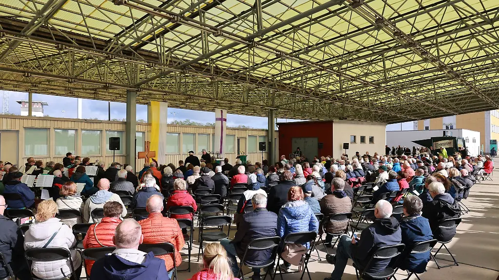 Besucher-sitzen-beim-traditionellen-oekumenischen-Bittgottesdienst-zum-Thema-Frieden-unter-dem-Gebaeude-der-PKW-Einreise-in-die-ehemalige-DDR-an-der-ehemaligen-Grenzuebergangsstelle-Marienborn