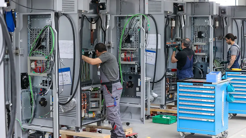 Mitarbeiter-verdrahten-im-Leipziger-Siemens-Werk-Ladesysteme-fuer-Elektroautos-Bei-der-Angleichung-der-Arbeitszeiten-ans-West-Niveau-sind-die-Betriebe-der-Metall-und-Elektroindustrie-in-Ostdeutschland-aus-Sicht-der-IG-Metall-auf-einem-guten-Weg