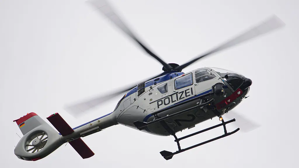 Ein-Polizeihubschrauber-fliegt-bei-einem-Sucheinsatz-ueber-eine-Stadt