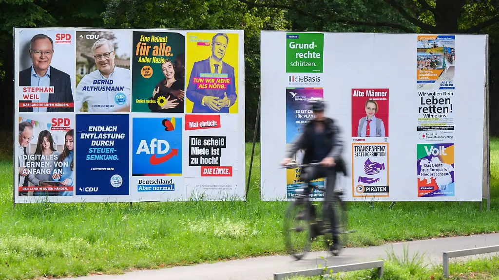 Ein-Radfahrer-radelt-an-einer-Wand-mit-Wahlplakaten-verschiedener-Parteien-vorbei-In-Niedersachsen-findet-am-9-Oktober-2022-die-Landtagswahl-statt