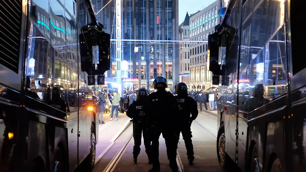 Polizisten-stehen-bei-einer-Kundgebung-auf-dem-Augustusplatz-zwischen-Wasserwerfern