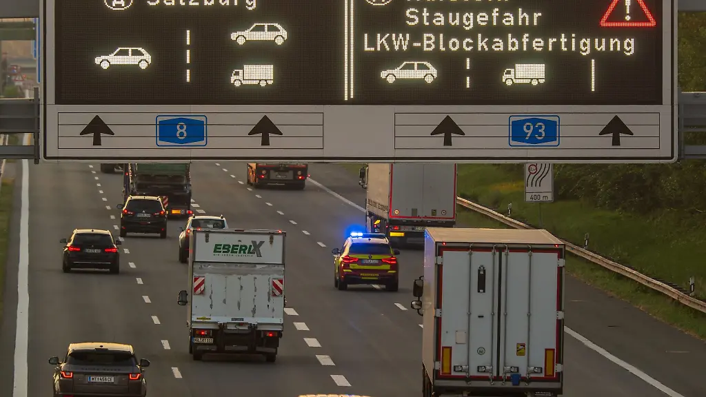 Ein-Verkehrsschild-mit-der-Aufschrift-Kufstein-Staugefahr-LKW-Blockabfertigung-steht-in-den-fruehen-Morgenstunden-auf-der-Autobahn-A8