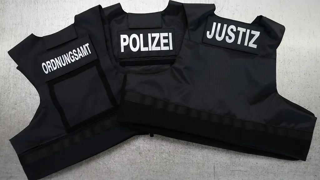 Schutzwesten-fuer-Ordnungsamt-Justiz-und-Polizei-liegen-auf-einem-Tisch